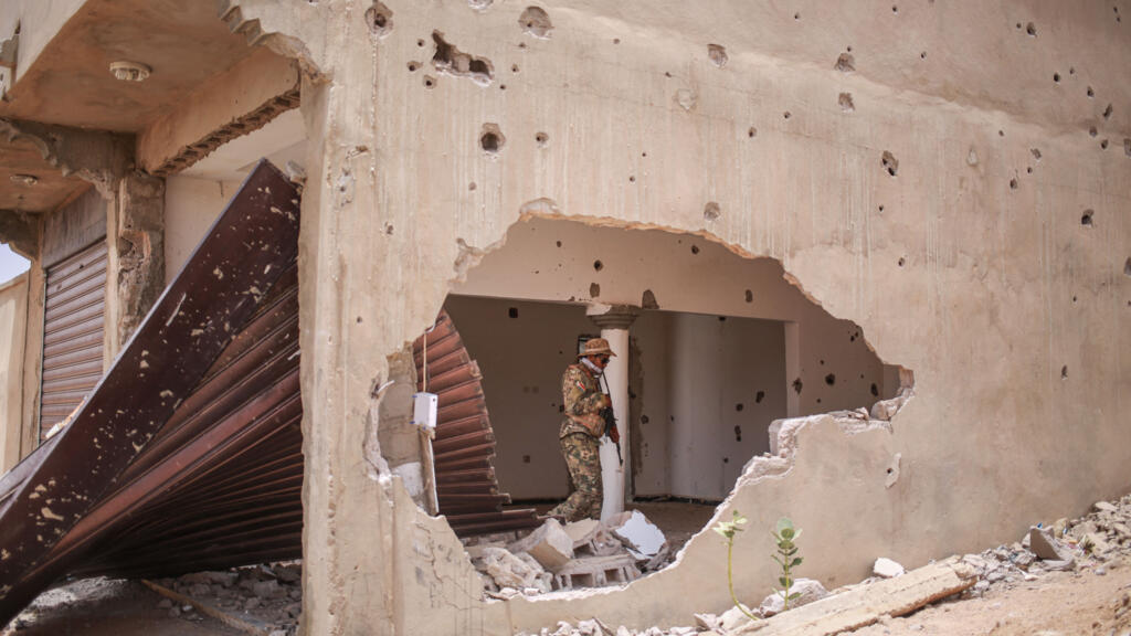 A soldier from the Azawad Liberation Front (FLA) walks through a damaged building in Kidal on May 9, 2026.