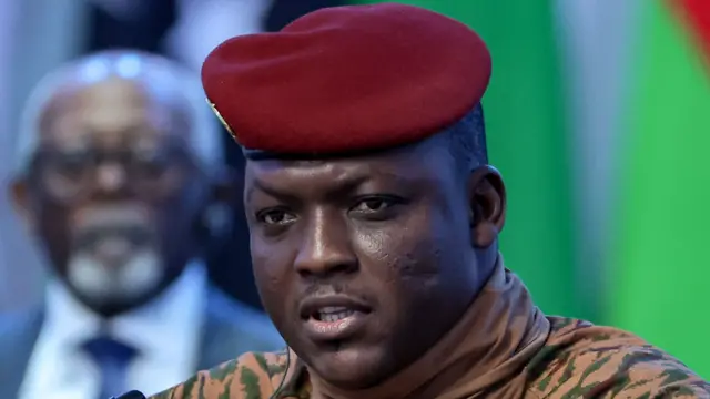 Close-up of Ibrahim Traoré wearing military attire with a red beret against a neutral background