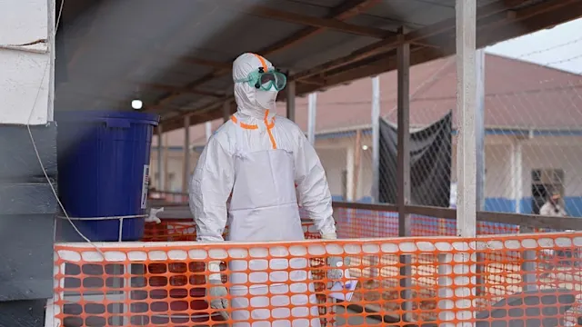 Healthcare workers in protective gear attending to patients