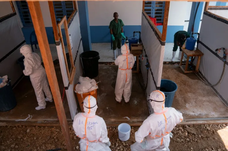 Healthcare workers in protective gear attending to patients during an Ebola outbreak in the Democratic Republic of Congo